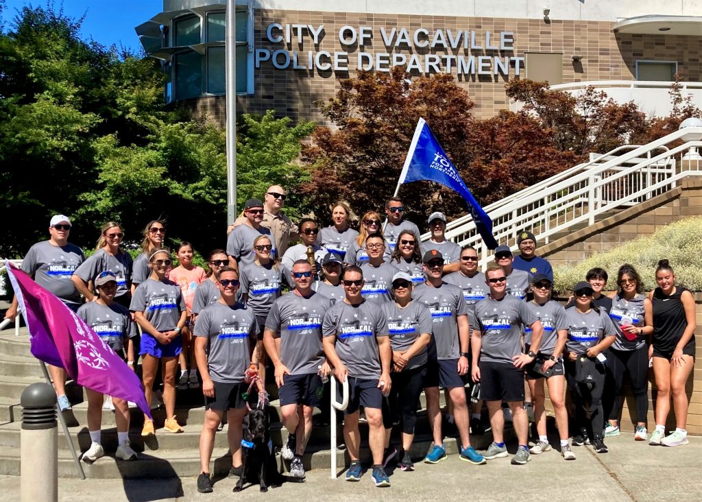 California Medical Facility volunteer runners pose for a group photo in front of the Vacaville Police Department office.