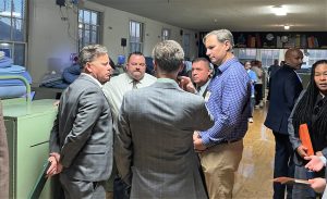 A group of people tour a dorm at California Rehabilitation Center as part of the program for incarcerated college students earning degrees.