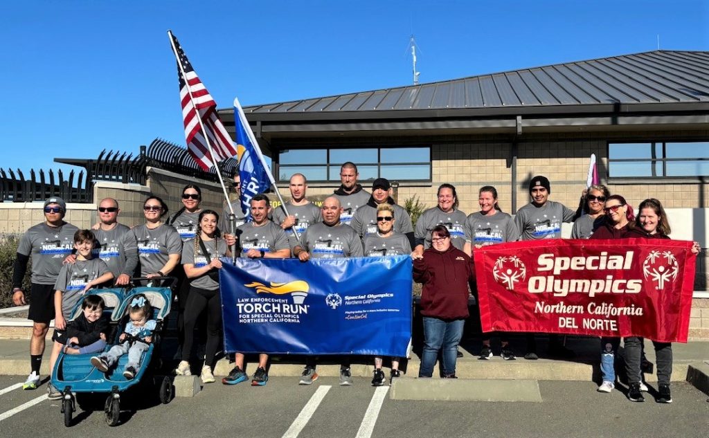 Del Norte County Special Olympics Torch Run with flags and banners.