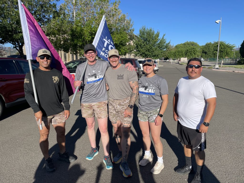Five people holding Law Enforcement Torch Run flags.