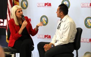 A formerly incarcerated person talks with the assistant general manager of CALPIA.