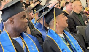 Incarcerated students wearing caps and gowns as they graduate a UC Irvine bachelor's degree program.