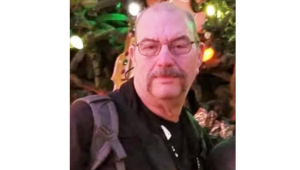 Gerald Robertson, with a holiday background, featured obituary image obituary.