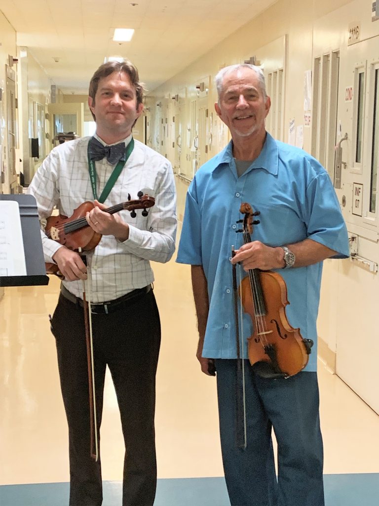 A staff member and incarcerated person with their violins at San Quentin Rehabilitation Center. 