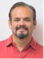 Victor Soto wearing a salmon color shirt and smiling.