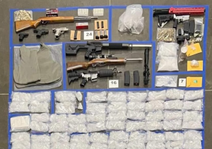 Photo of seized drugs, guns and ammunition sitting on an evidence table collected by officers during Operation SLO Ride.