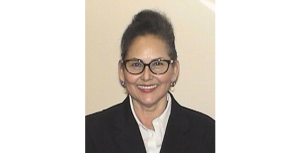 Leticia Tellez obituary featured image, retired correctional officer smiling and wearing glasses.