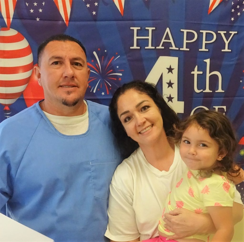 An incarcerated man with a woman holding a baby.