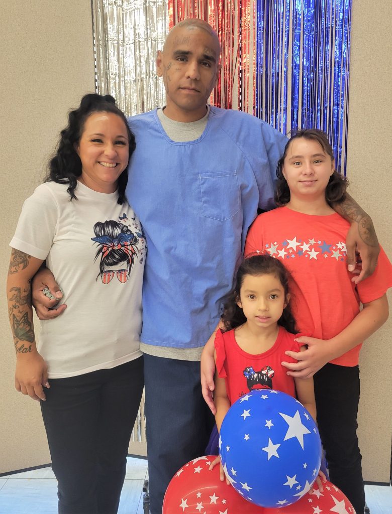 An incarcerated person visiting with family for Fourth of July in Tehachapi.