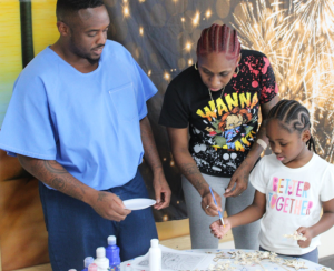 An incarcerated person and two family members visiting for July Fourth at Centinela State Prison.