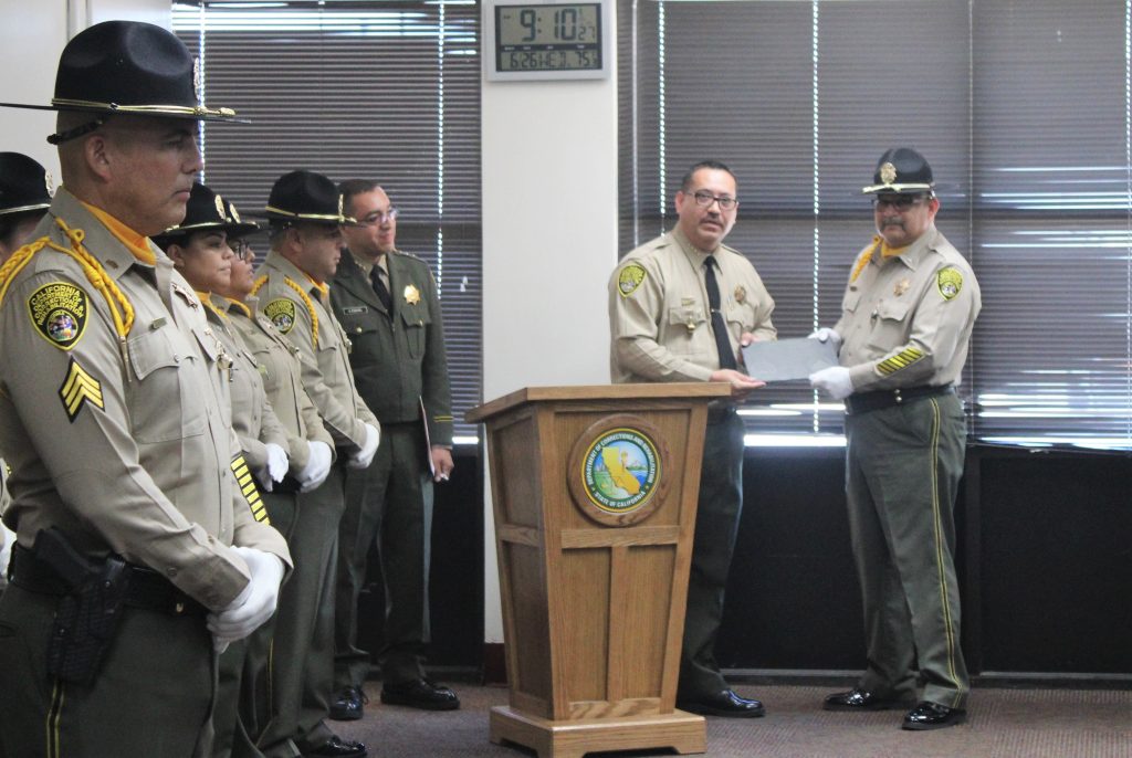 Warden shakes hands with honor guard commander.