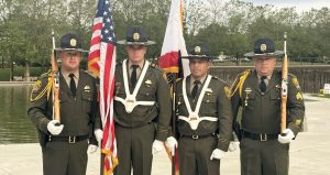 Four members of the Mule Creek State Prison Honor Guard holding flags and ceremonial rifles as they prepare for the Project 2000 memorial ceremony in Seattle, Washington.