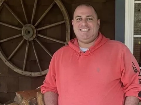 Trevor Ramsey standing with a wagon wheel behind him.