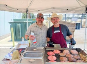 two El Monte District staff flipping burgers