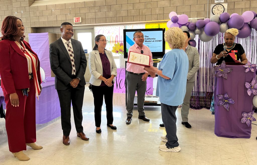 A graduate receives her certificate at CCWF.