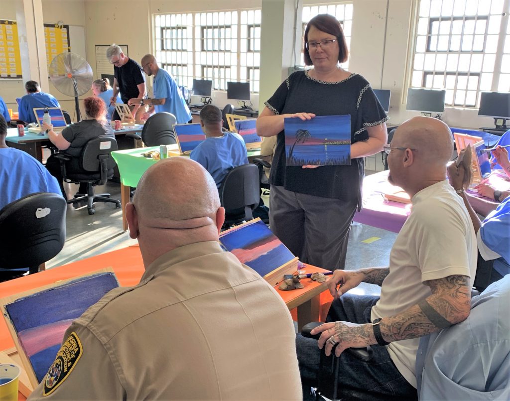 CMF principal gives pointers on painting to staff and incarcerated people.