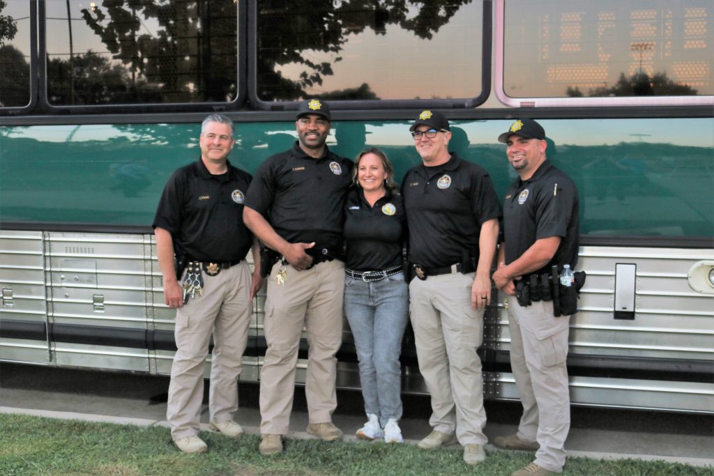 Five CDCR staff members stand in front of a bus at Galt National Night Out.