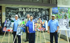 Staff member with incarcerated artists and their displays.