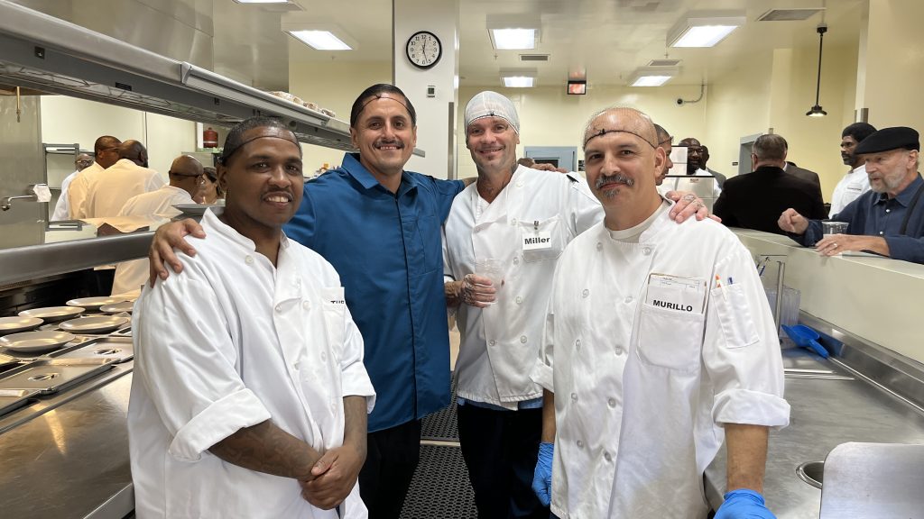 Four incarcerated people in a restaurant kitchen.