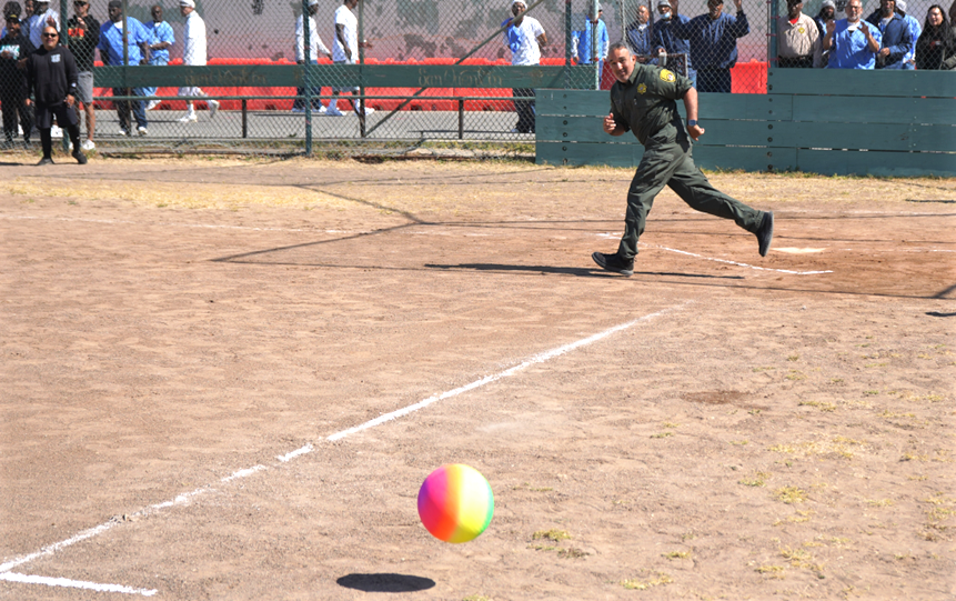 Kickball event with correctional officer running to a base.