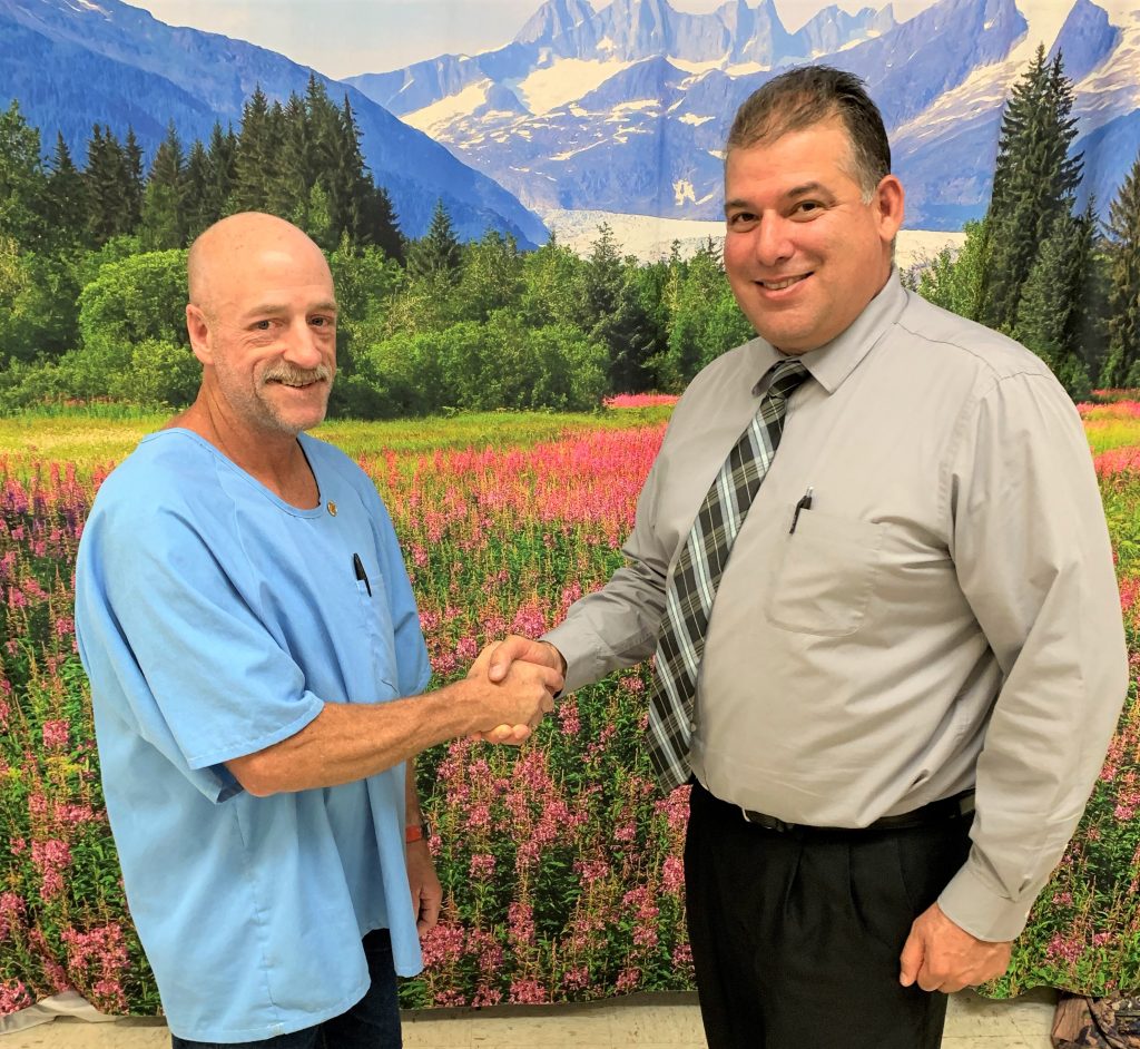 CMF Warden shaking hands with incarcerated