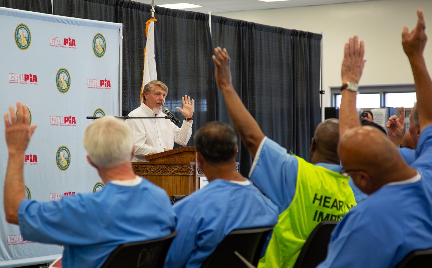 CALPIA General Manager Bill Davidson at a lectern during a graduation ceremony.