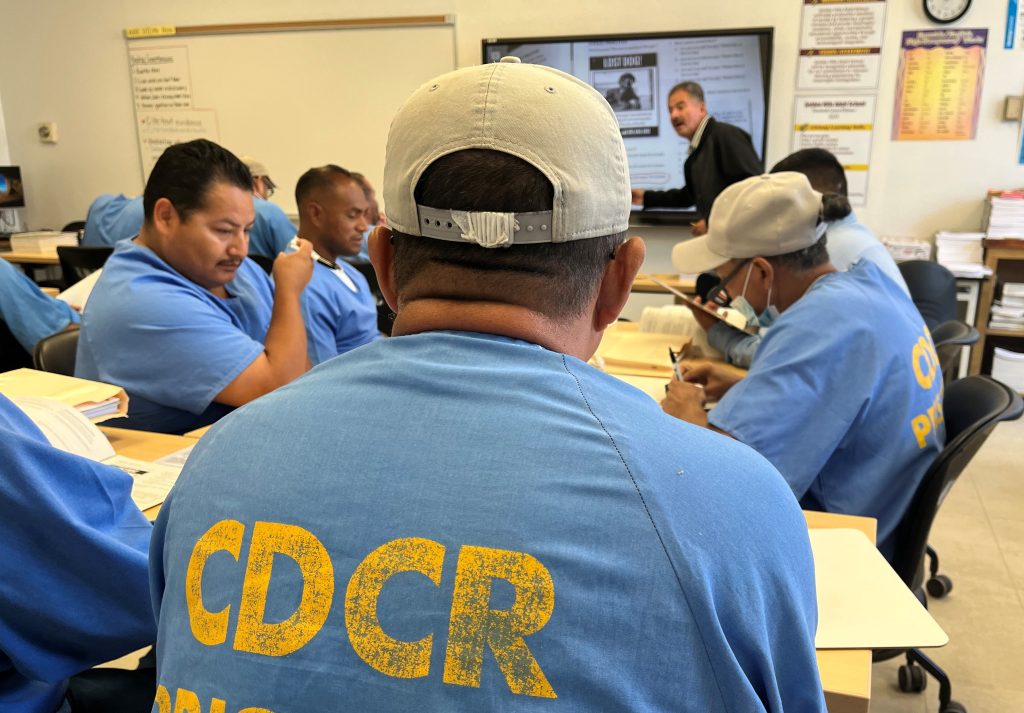 A group of incarcerated students listen as teacher Pedro Rios gives a lesson at Avenal State Prison.