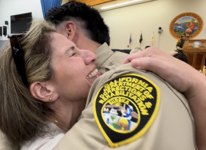 A new correctional officer receives a hug after graduating the academy.