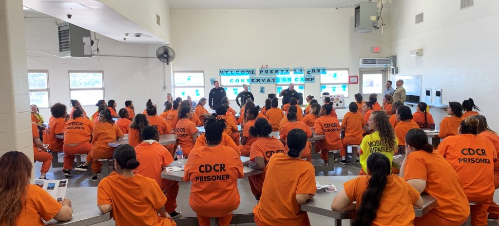 A group of incarcerated women learn about opportunities at a recruitment event for the conservation camp program.