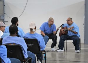 An incarcerated man plays guitar in Centinela State Prison as part of a talent show.