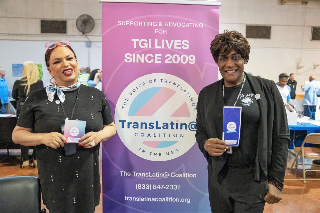 Two people with Trans-Latin Coalition hold brochures.