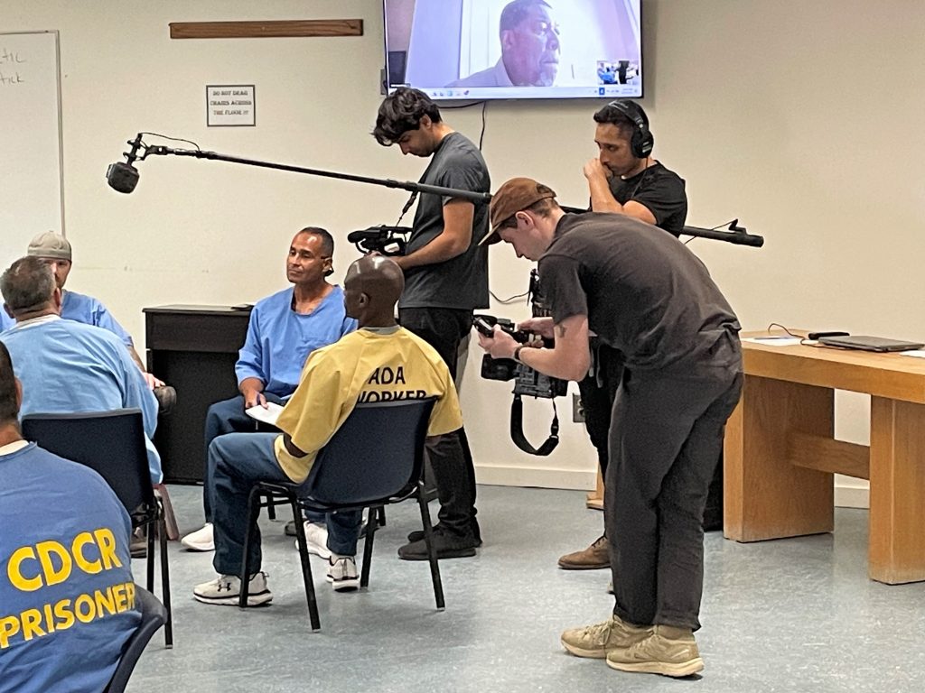 Filmmakers with camera at High Desert State Prison during a meeting of the Lifers Group.