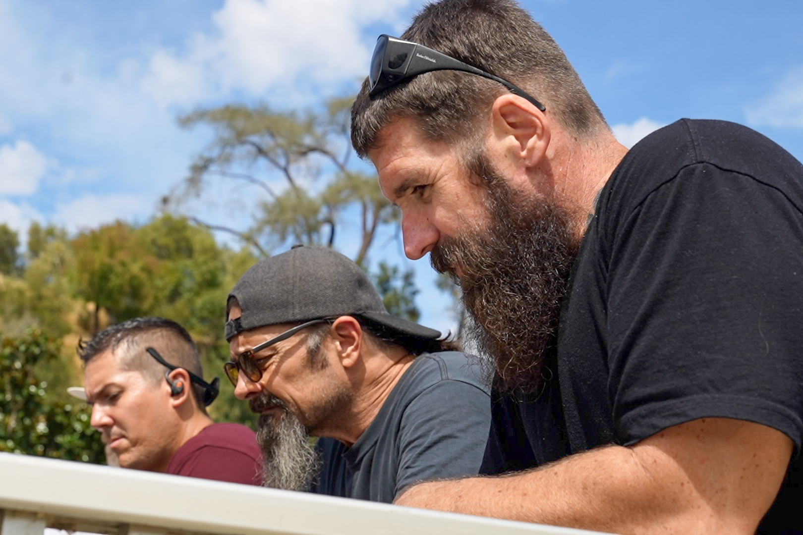 Three Butte County reentry participants watch salmon and trout at the fish hatchery.