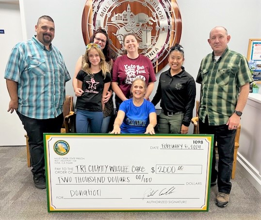 Group photo of a community organization receiving a check from Mule Creek prison fundraising efforts. 