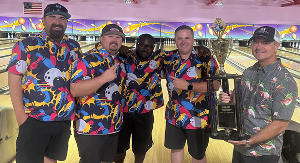men in bowling shirts with trophy