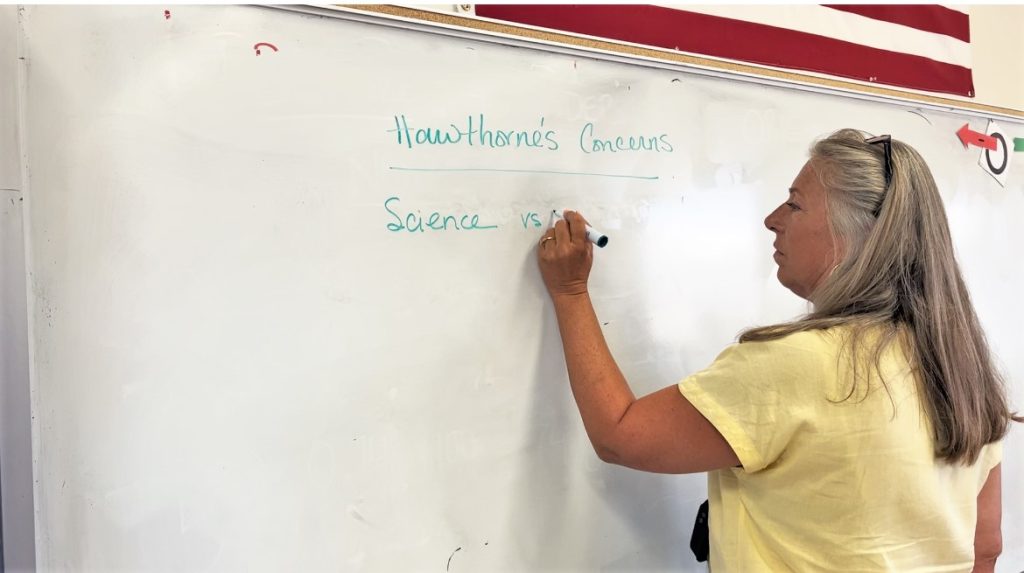 Education instructor writes on a whiteboard. 