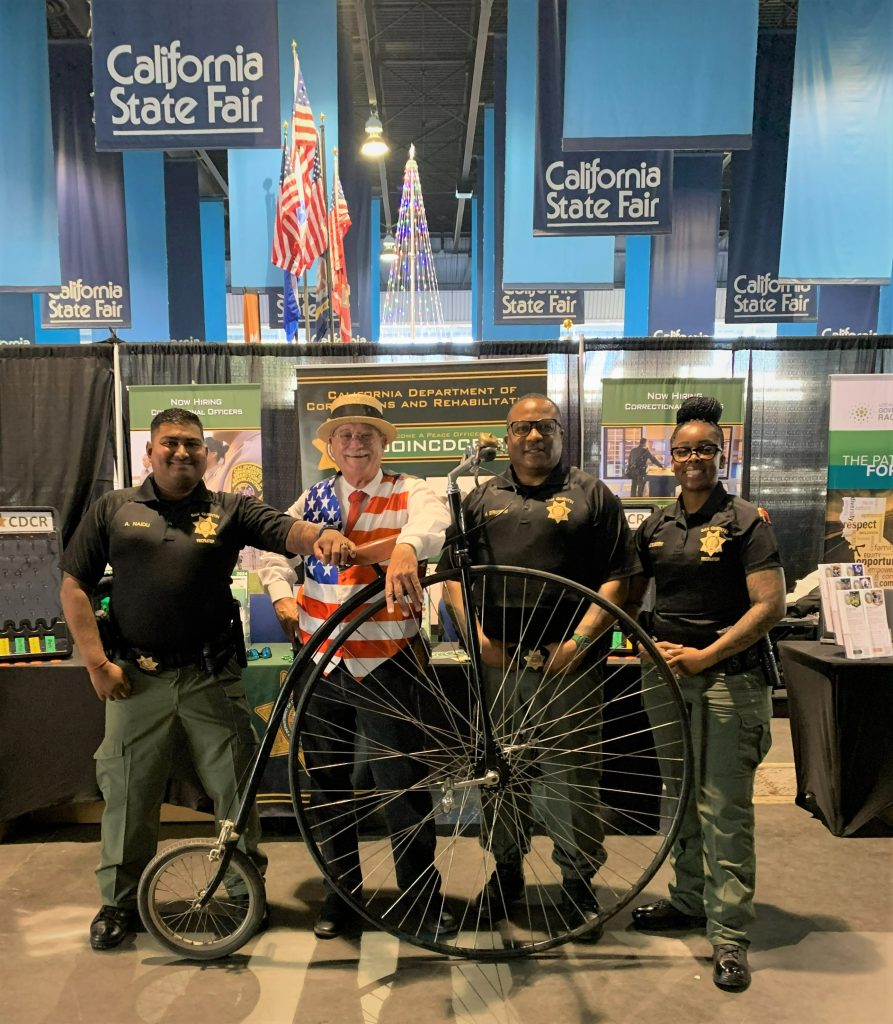 three Peace Officer Recruitment staff with fair cyclist