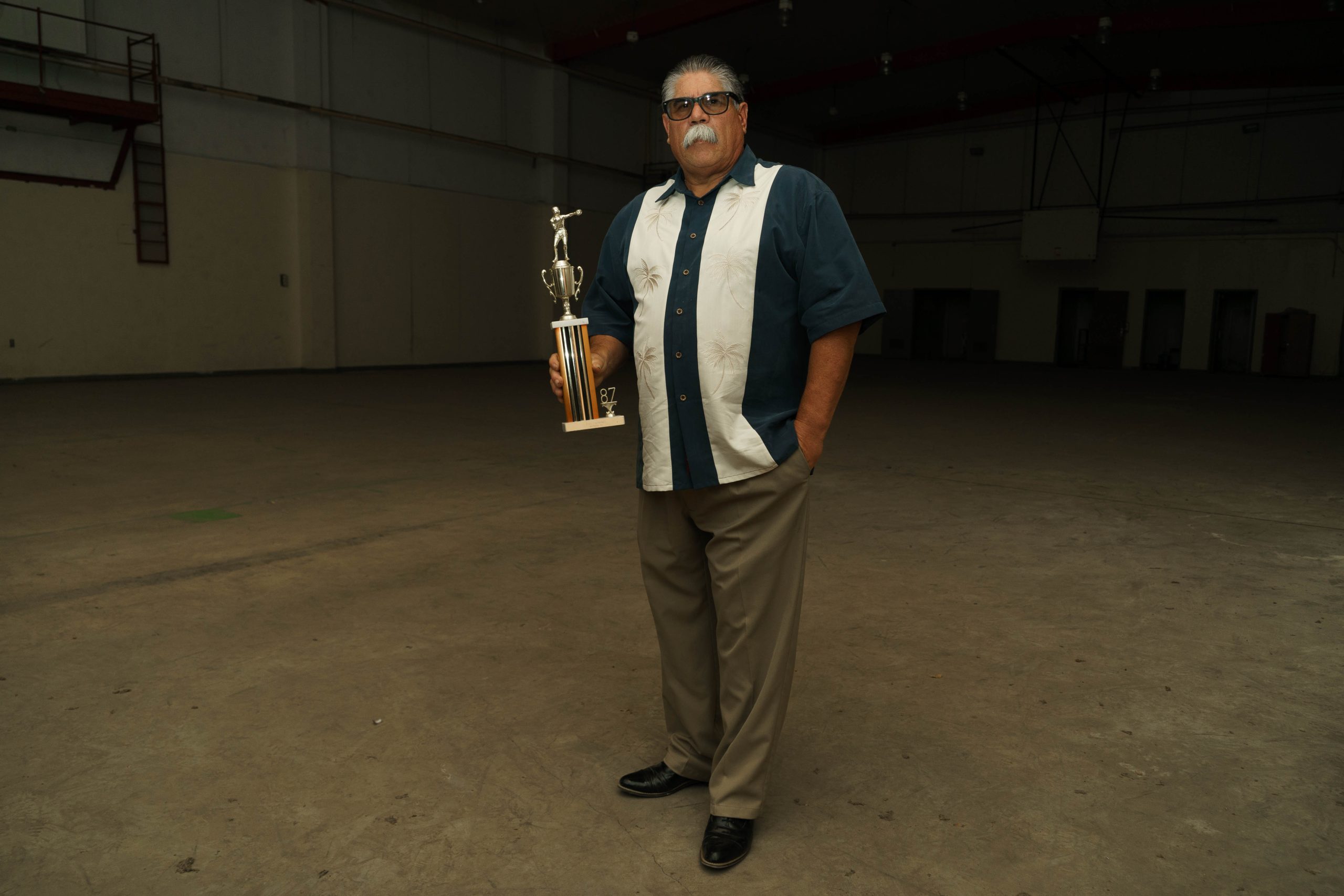 A formerly incarcerated youth, now four decades later, holding his boxing trophy.