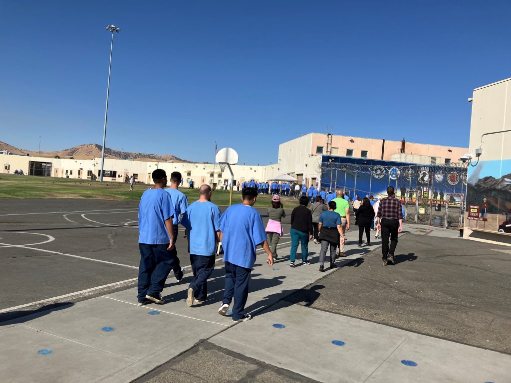 Avenal State Prison incarcerated and staff walking on the yard.