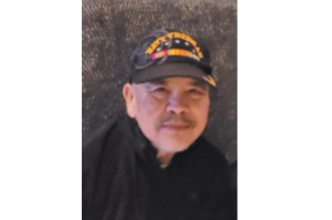 Manuel Adlao wearing a Navy veteran hat.