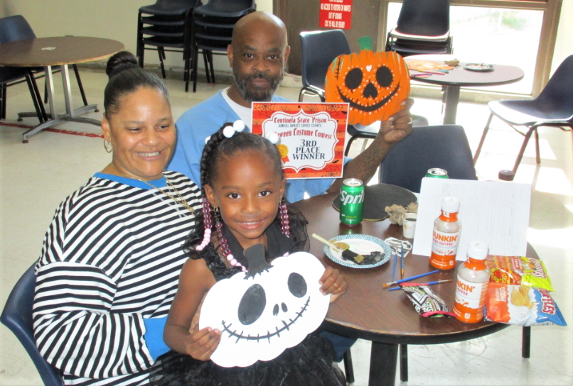 A family holds Halloween decorations in Centinela State Prison.