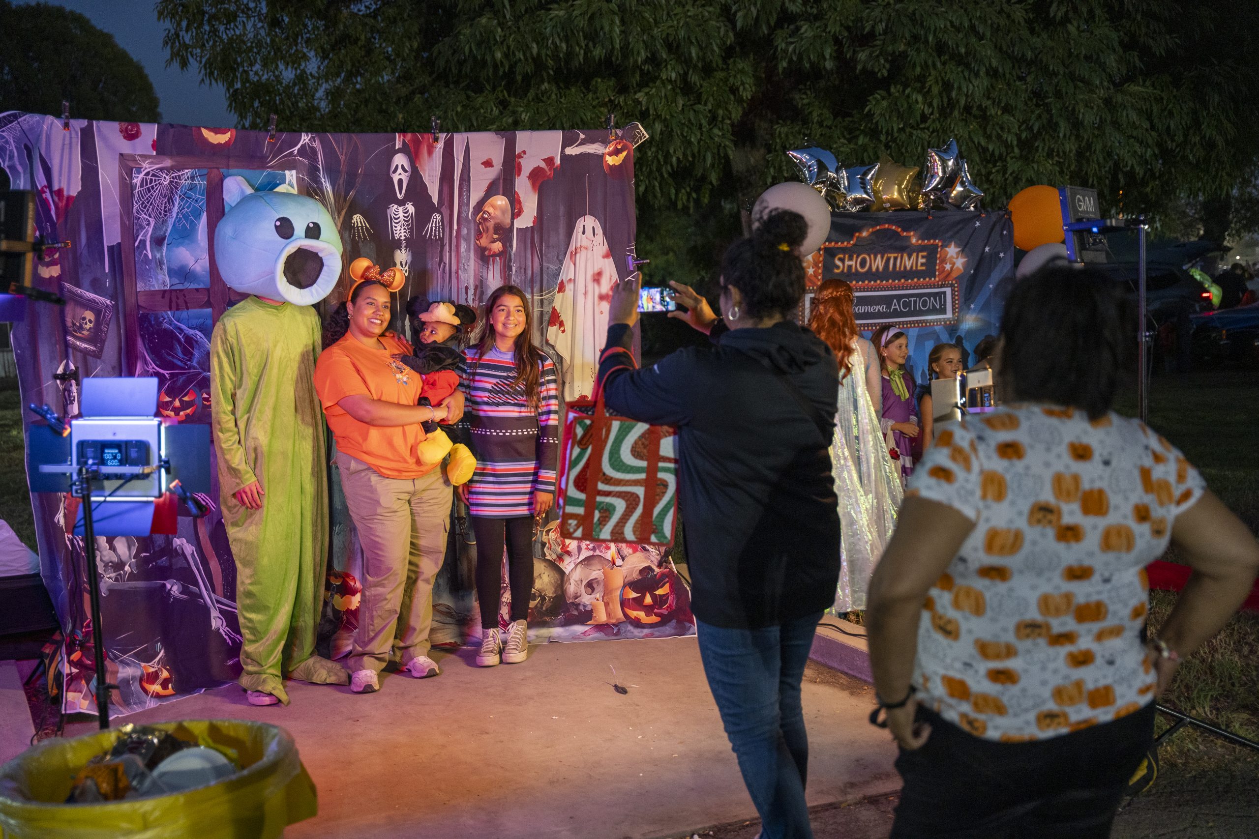 A family takes photo at California Institution for Men's trunk-or-treat event.