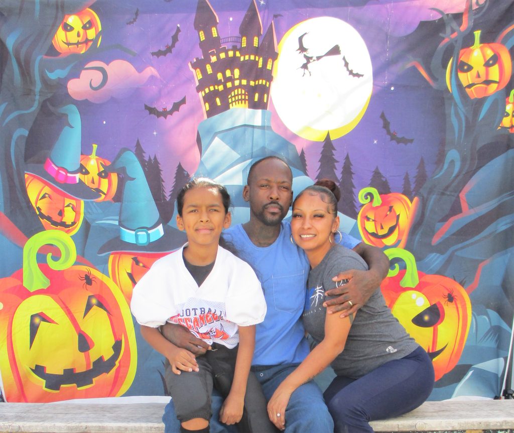 Family photo with Halloween backdrop at California Institution for Men.