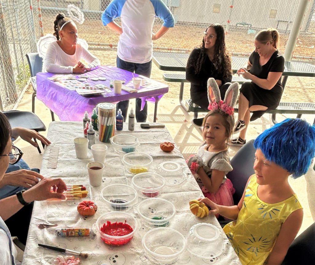 Children decorate mini pumpkins at CIW.