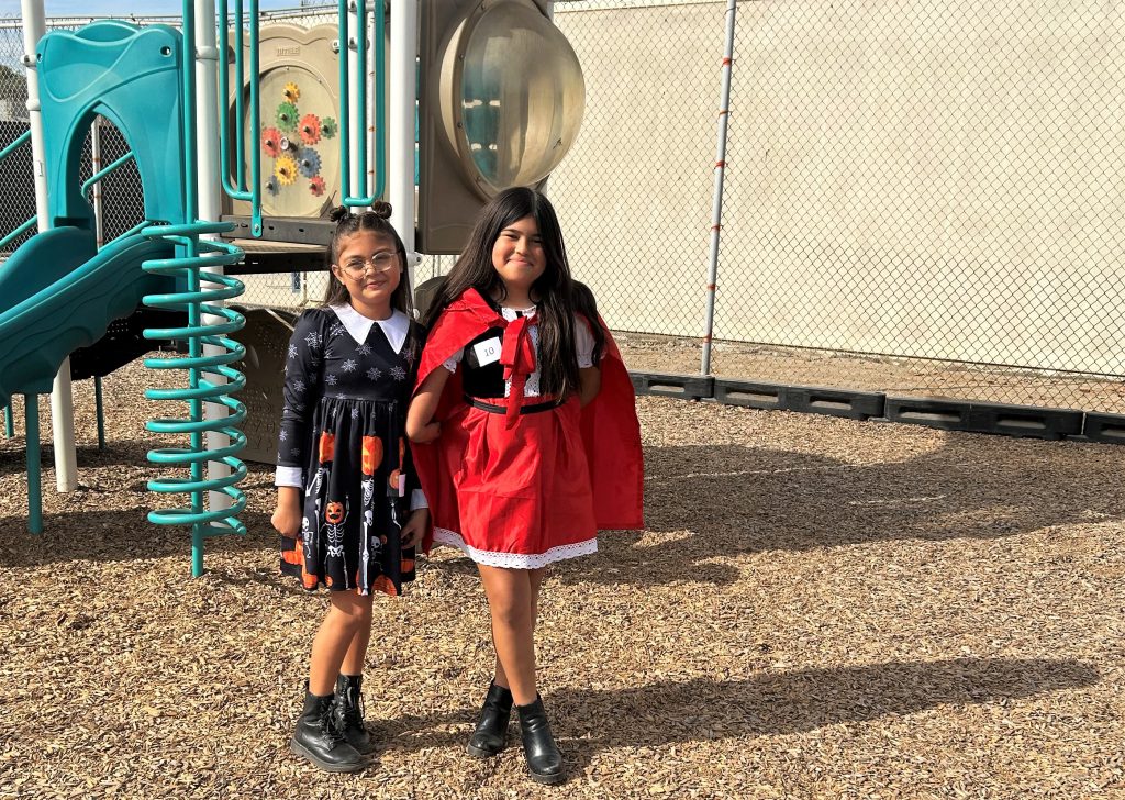 Two young girls wear costumes at CIW.