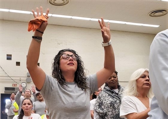 A woman raises her hands during a sobriety resource fair at CIW.