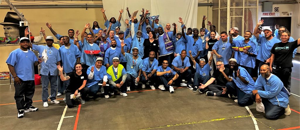Group photo of incarcerated artists and volunteers at the Correctional Training Facility in Soledad.