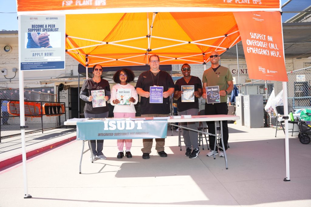 Folsom State Prison overdose awareness day with five people standing under a tent.