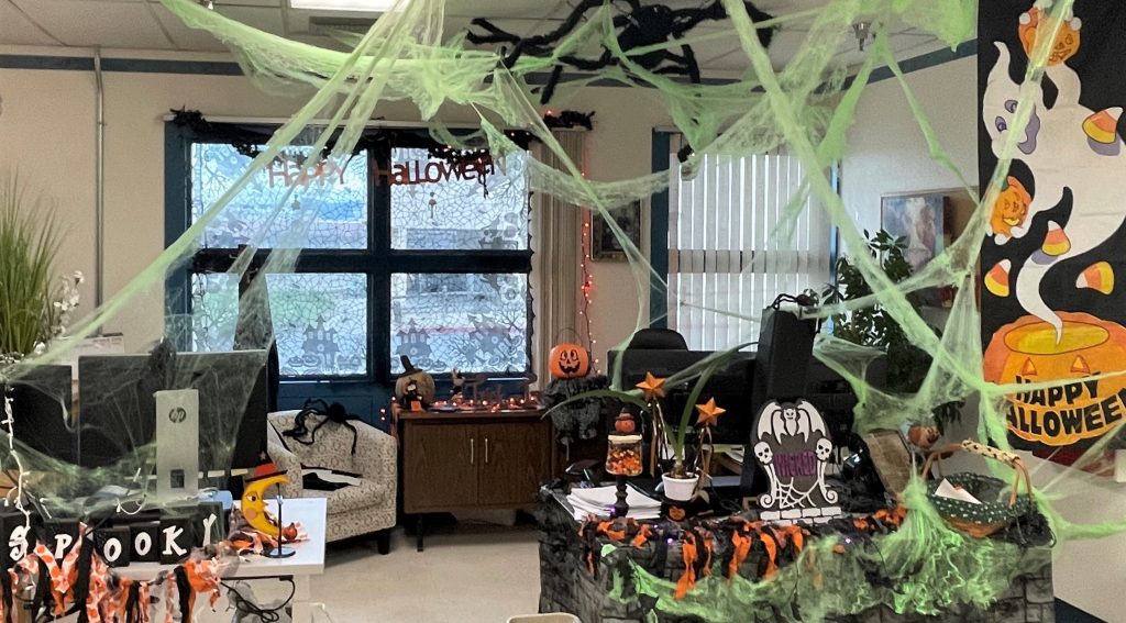 Decorated work areas at High Desert State Prison in Susanville, California, with cobwebs and a big fake spider hanging from the ceiling tiles.