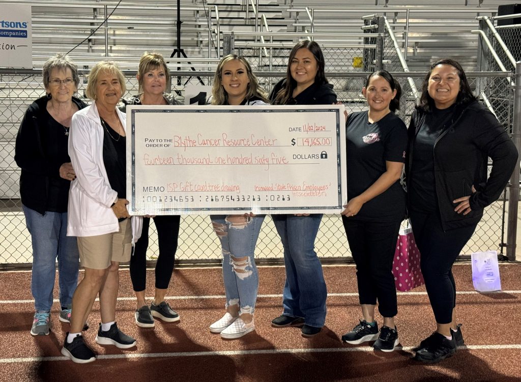 ISP staff holding check donation for cancer awareness